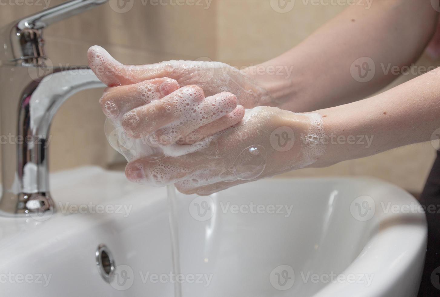 igiene. lavarsi le mani. lavarsi le mani con il sapone. mano di donna con schiuma. proteggiti dalla pandemia del coronavirus covid-19 foto