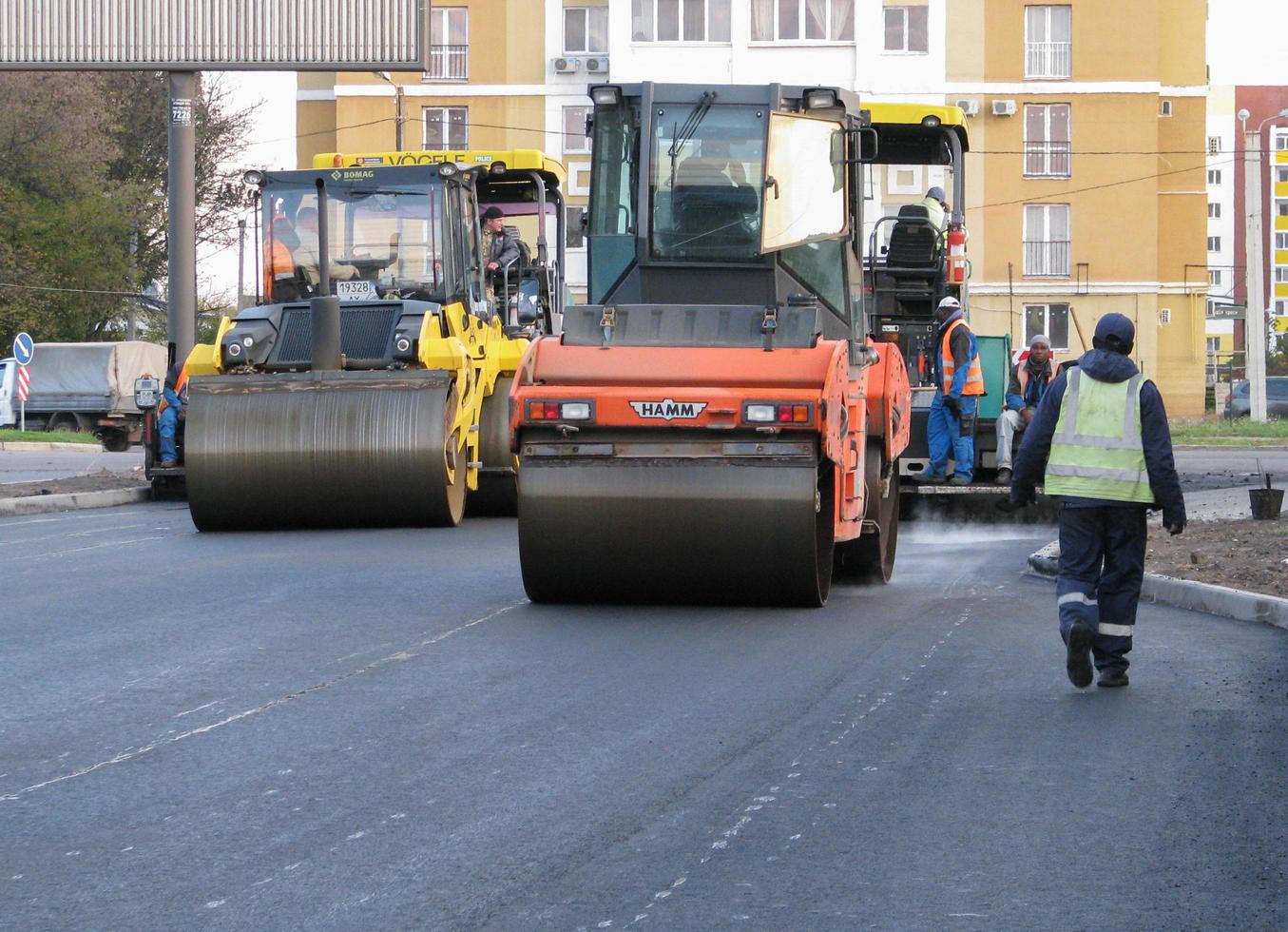 ucraina, kharkiv, 27 ottobre 2020. vista ravvicinata sui lavoratori e sulle macchine asfaltatrici. rullo e addetti all'asfaltatura e riparazione di strade cittadine. foto di alta qualità