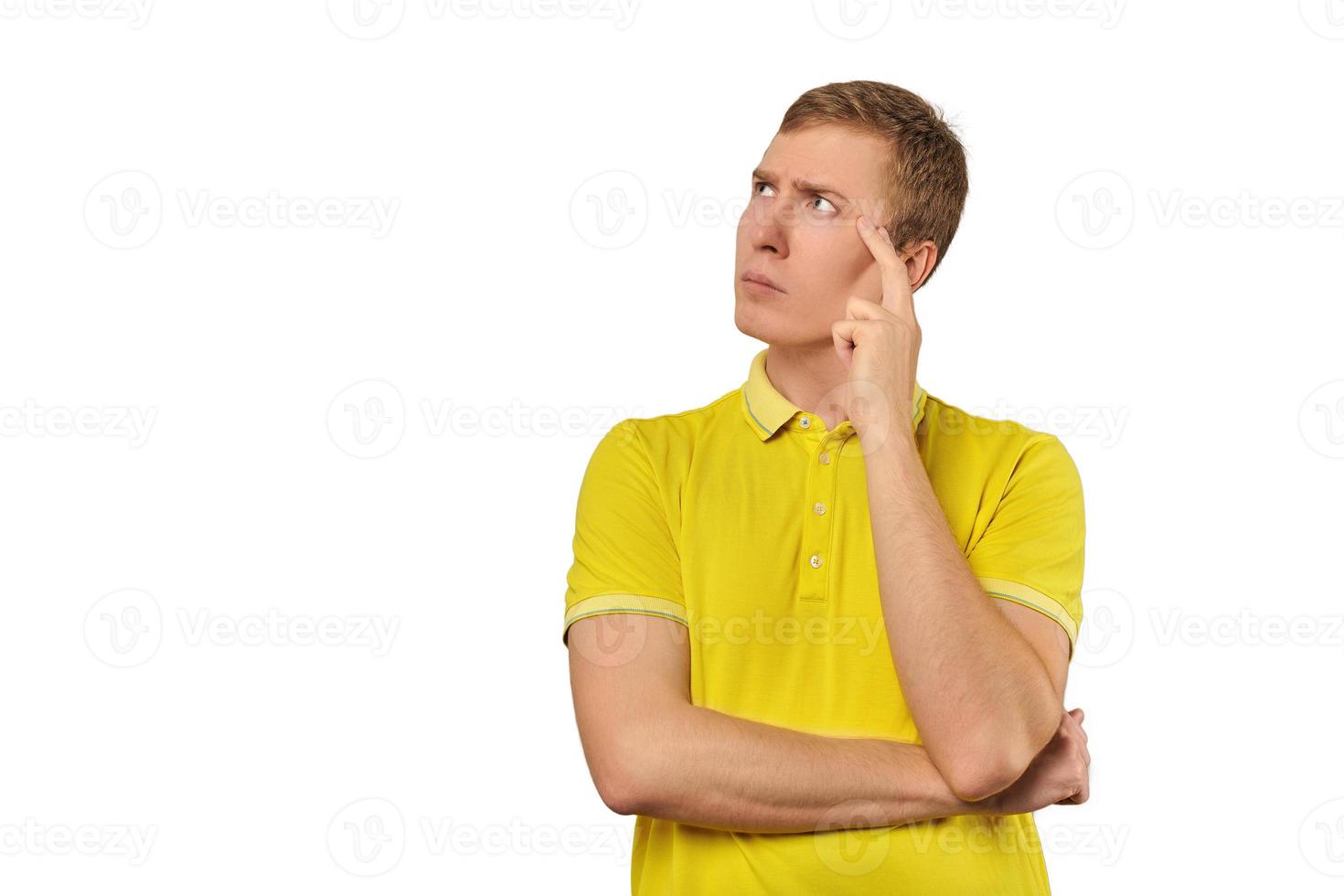 ragazzo premuroso in maglietta gialla che guarda a sinistra, sfondo bianco, riflessione filosofica foto