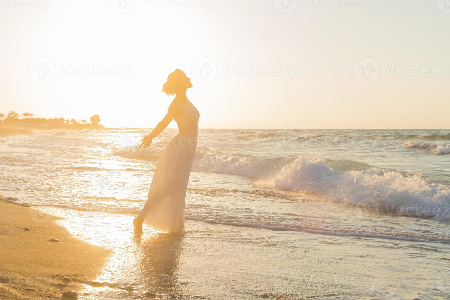 giovane donna gode di camminare su una spiaggia nebbiosa al crepuscolo. foto