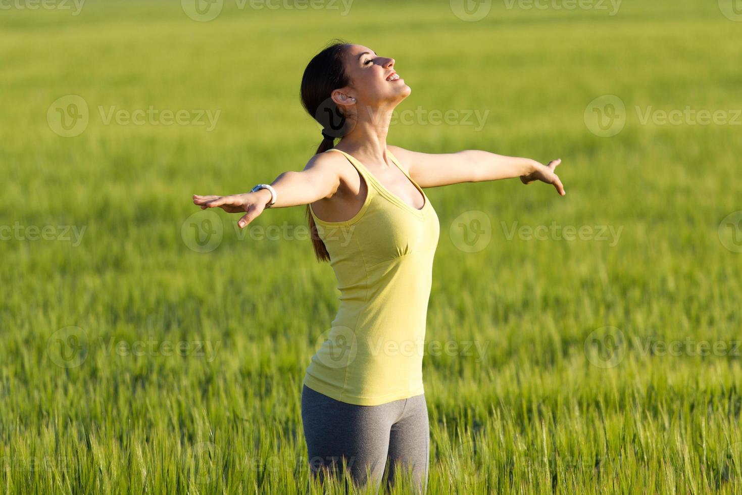 giovane donna godendo la primavera in piedi in un campo di cereali foto