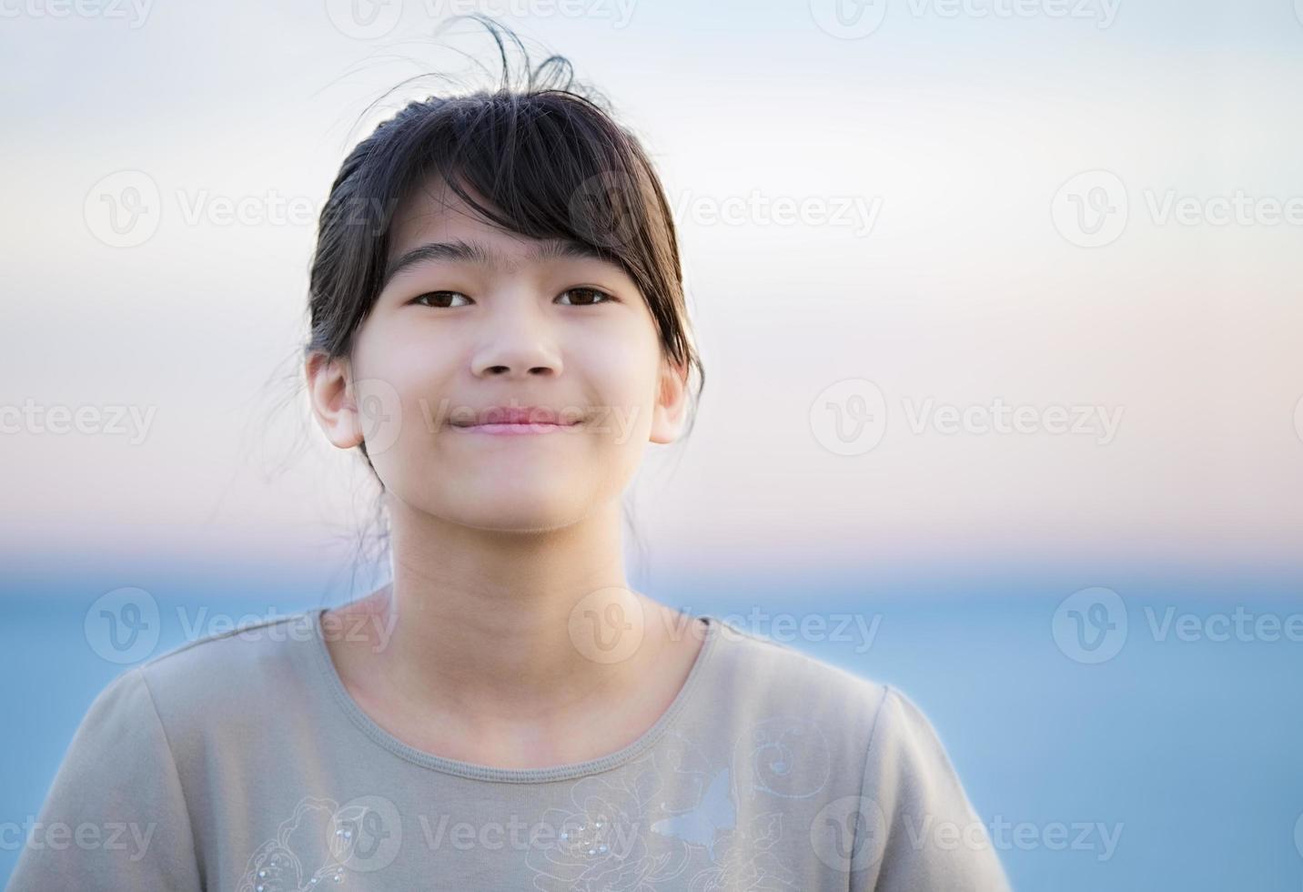bella ragazza giovane del preteen che gode all'aperto dal lago al tramonto foto