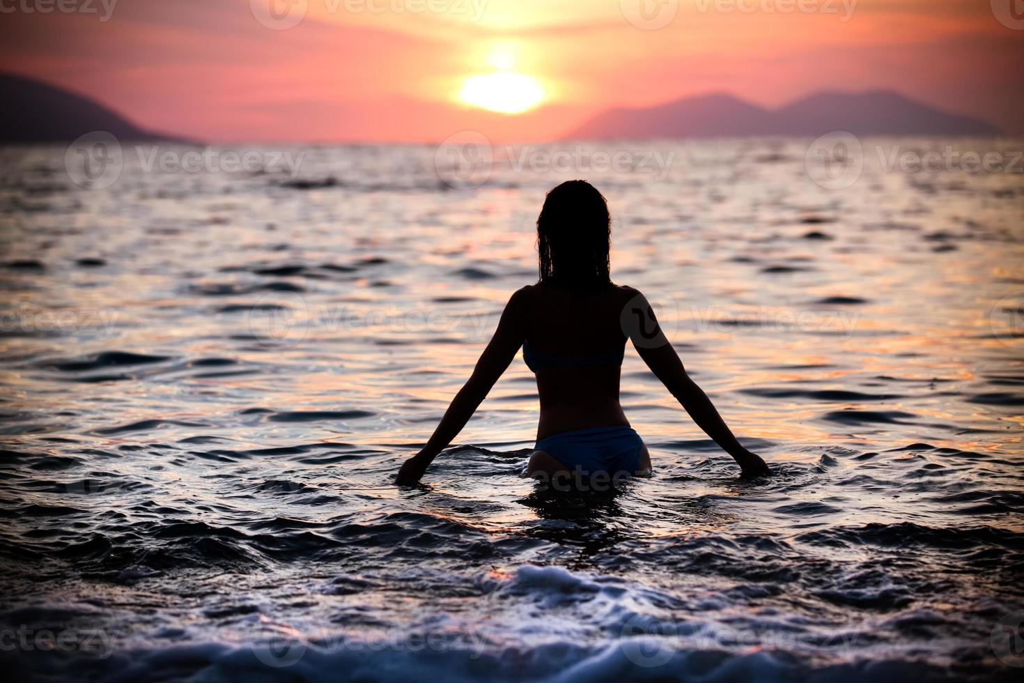nuoto splendido della siluetta della donna di misura nella donna di sunset.free che gode del tramonto. foto