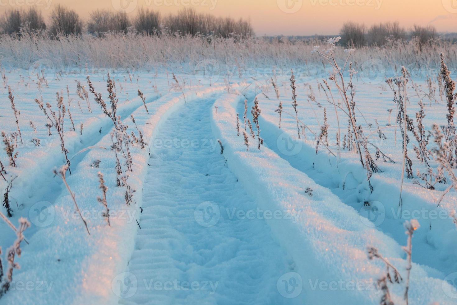 paesaggio invernale, tracce di pneumatici sulla neve, strada innevata foto