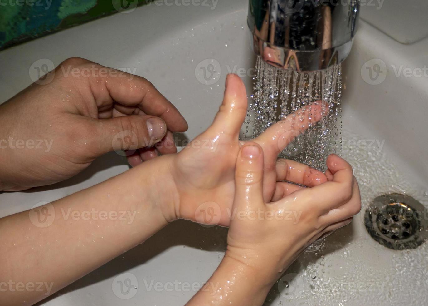 primo piano di uomo caucasico e bambino si lava le mani in bagno. covid - 19 prevenzione foto