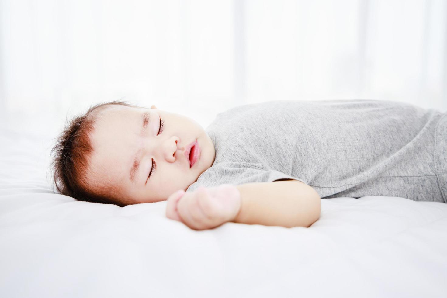 dormire carina bambina sul letto durante il giorno. protezione dei bambini. foto