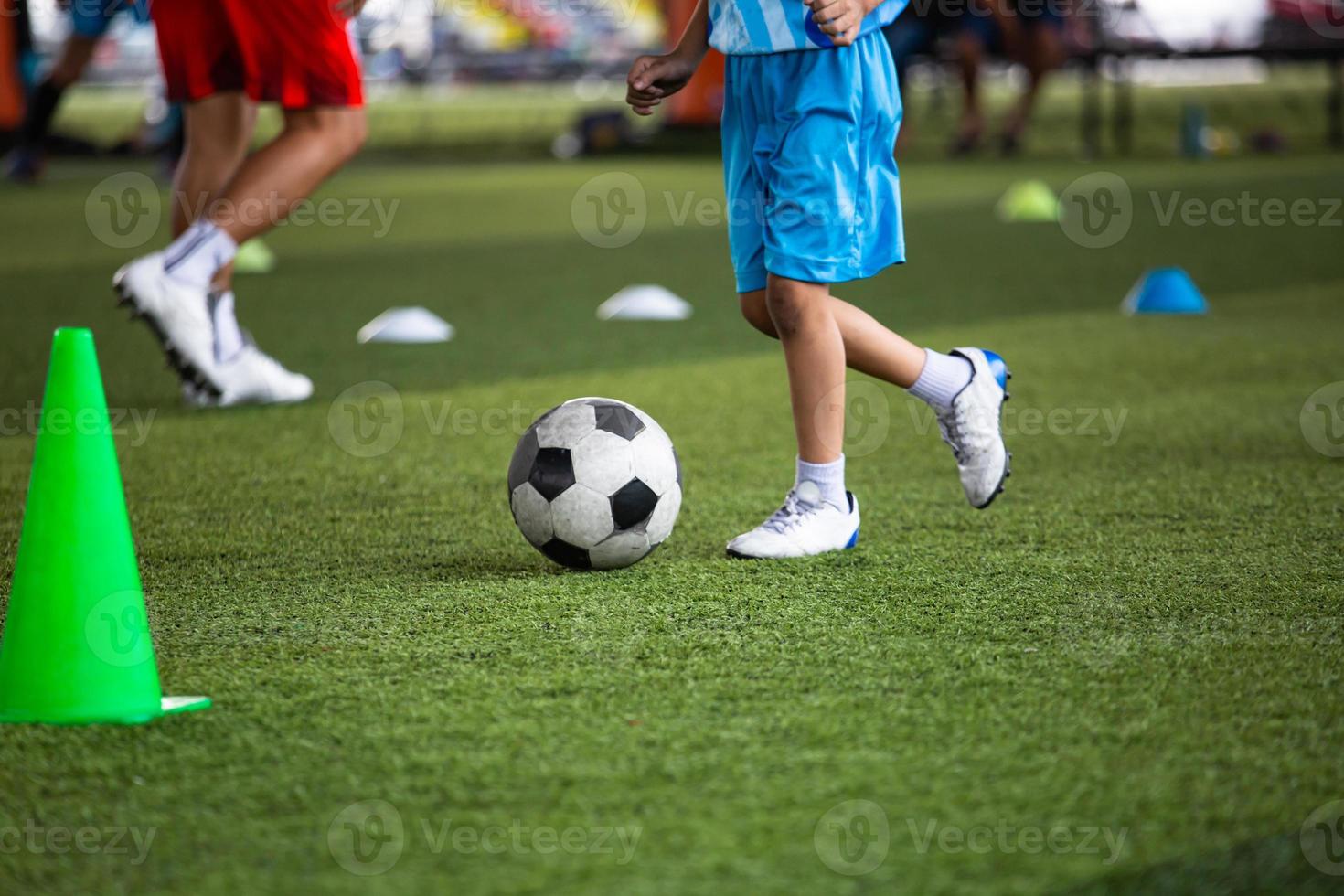 tattiche del pallone da calcio dei ragazzi sul campo in erba con il cono foto