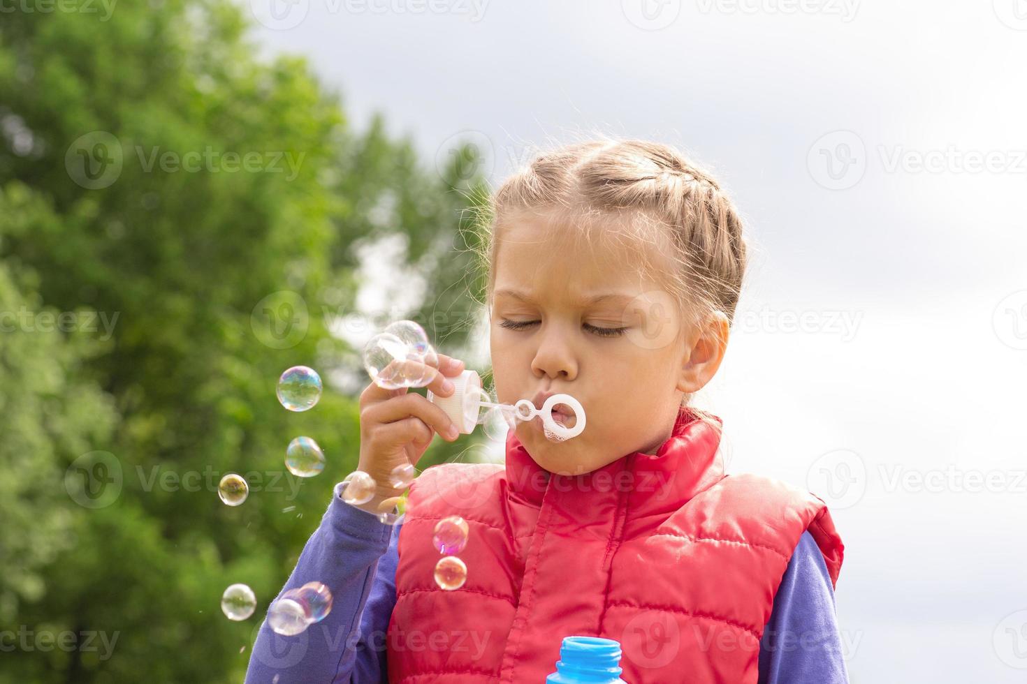 bambino che soffia bolle in estate foto