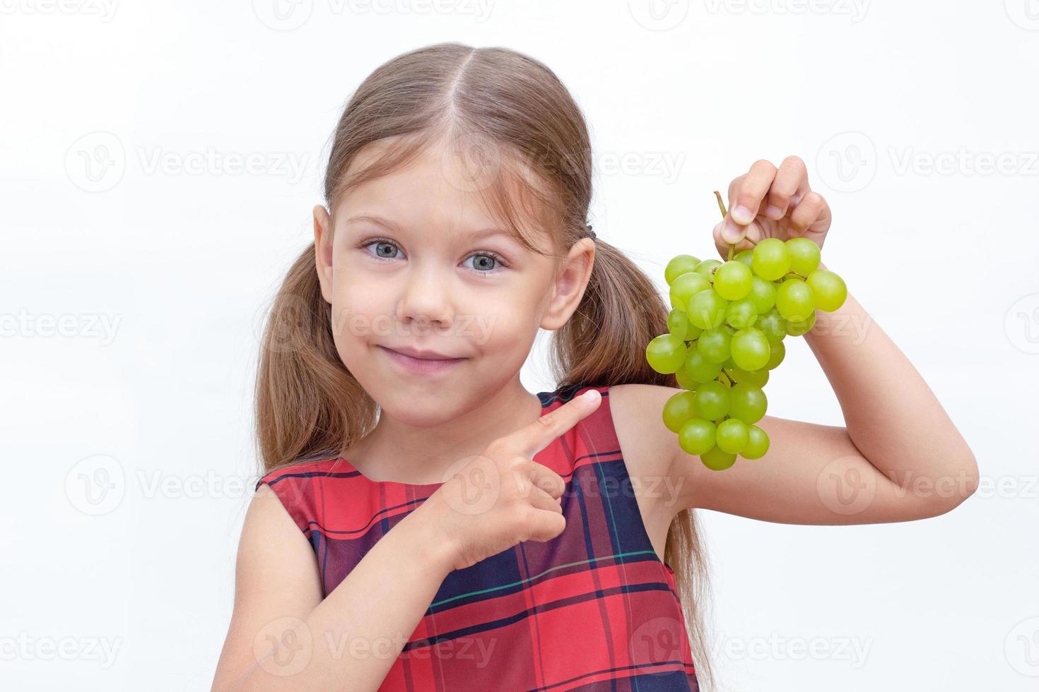 bambino che tiene grappolo d'uva foto