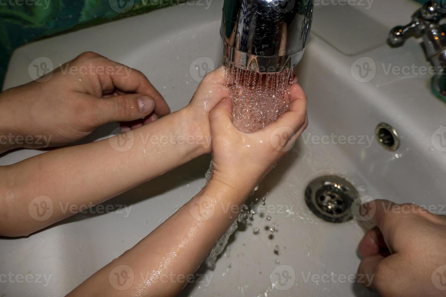 primo piano di uomo caucasico e bambino si lava le mani in bagno. covid - 19 prevenzione foto