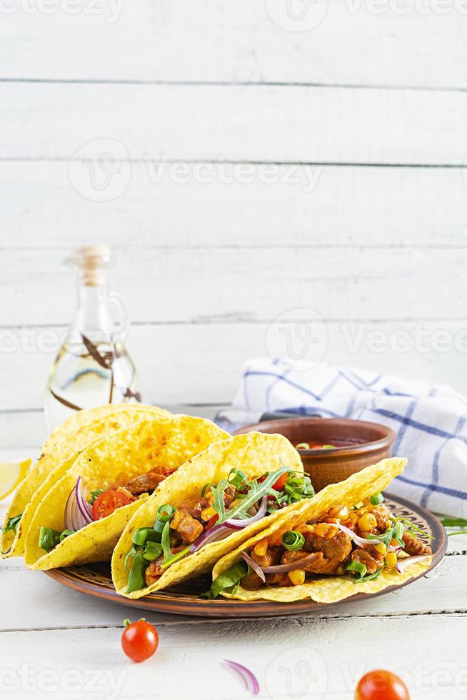 tacos messicani con tortilla di mais e carne su fondo di legno foto