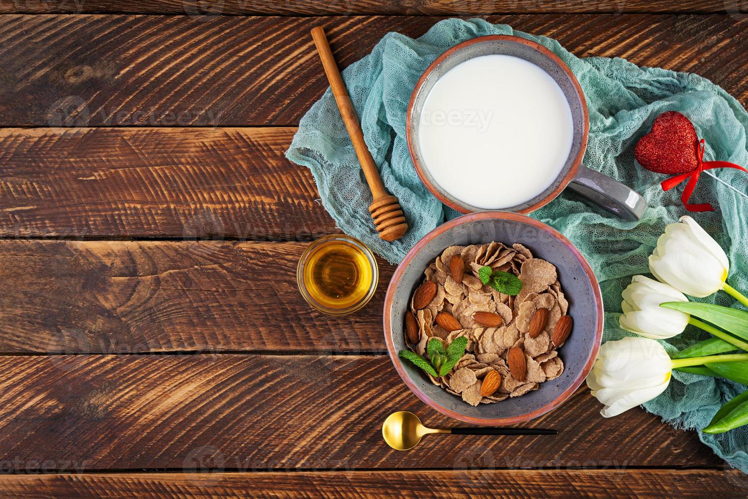 fiocchi di farro con latte a colazione. colazione leggera a san valentino con tulipani e cuore foto