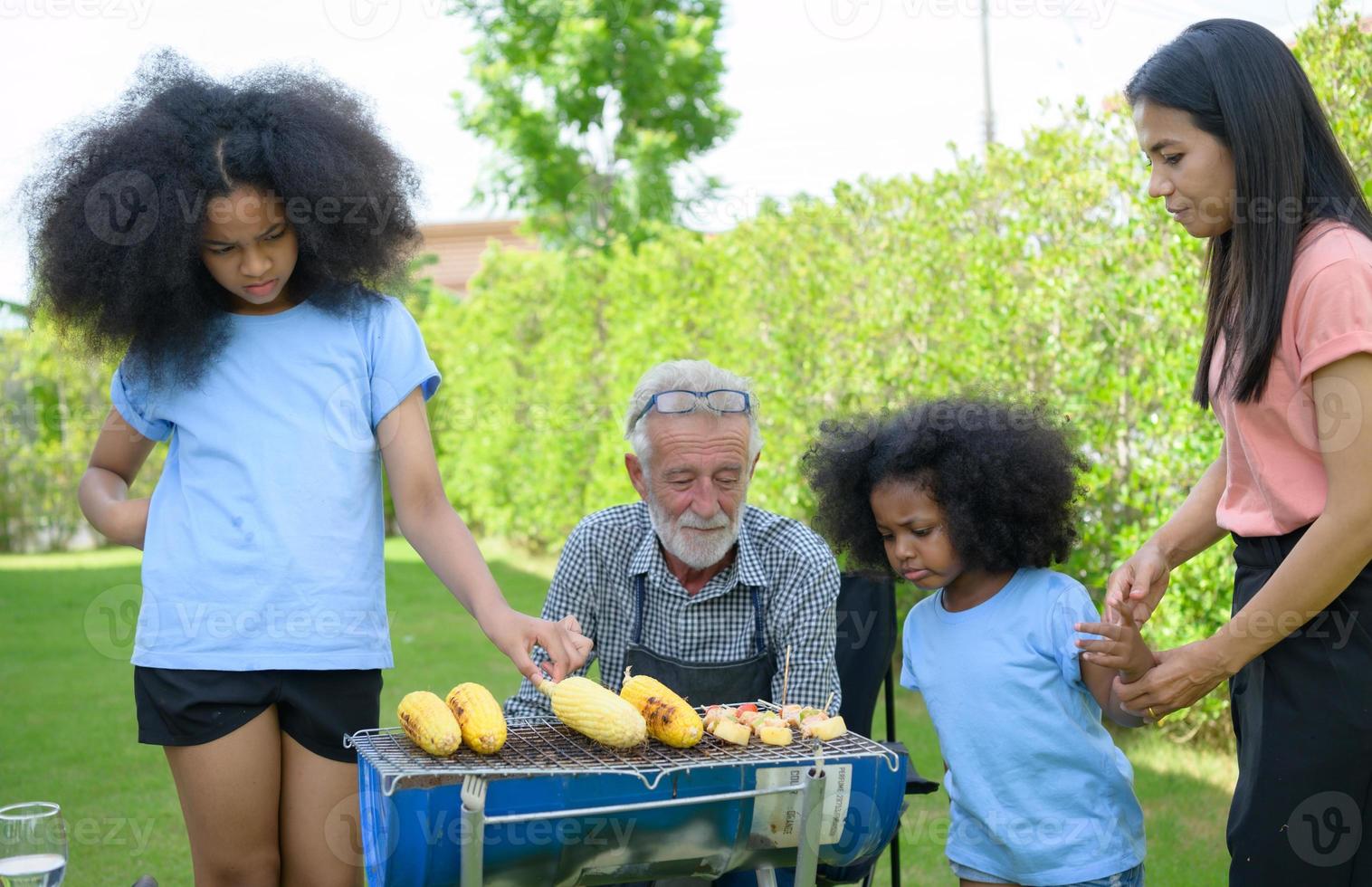 attività di vacanza in famiglia con nonno, madre e bambini con campeggio. barbecue grill e giocare in cortile insieme felicemente in vacanza. foto