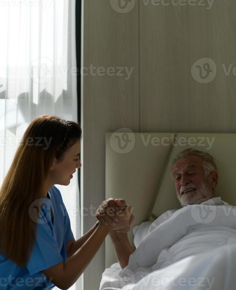 il dottore sta parlando con un paziente anziano che è solo in una stanza d'ospedale speciale. foto