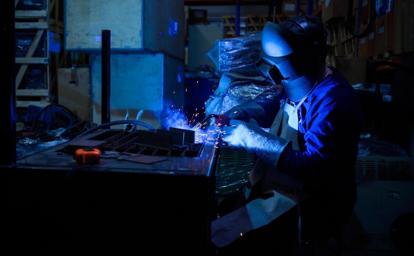 un saldatore sta lavorando per saldare il metallo. per creare un lavoro di qualità secondo la forma prescritta foto