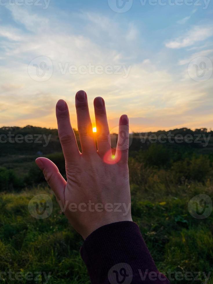 mano sullo sfondo del tramonto foto