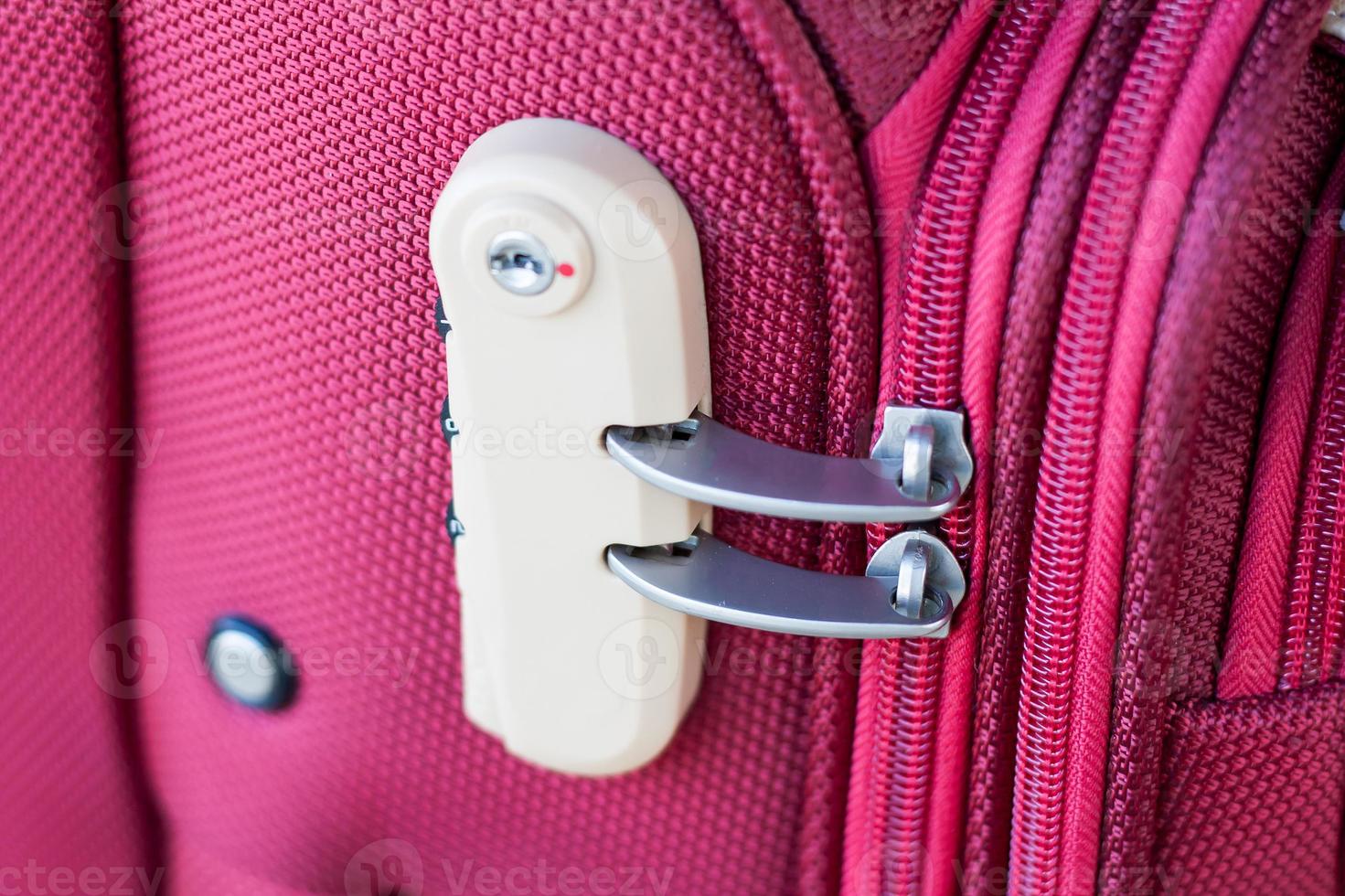 serratura a combinazione sulla borsa da viaggio valigia rossa foto
