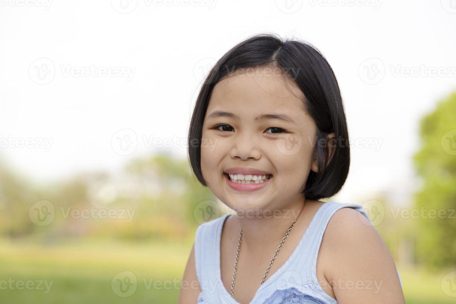 bambina asiatica che sorride felicemente nel parco foto