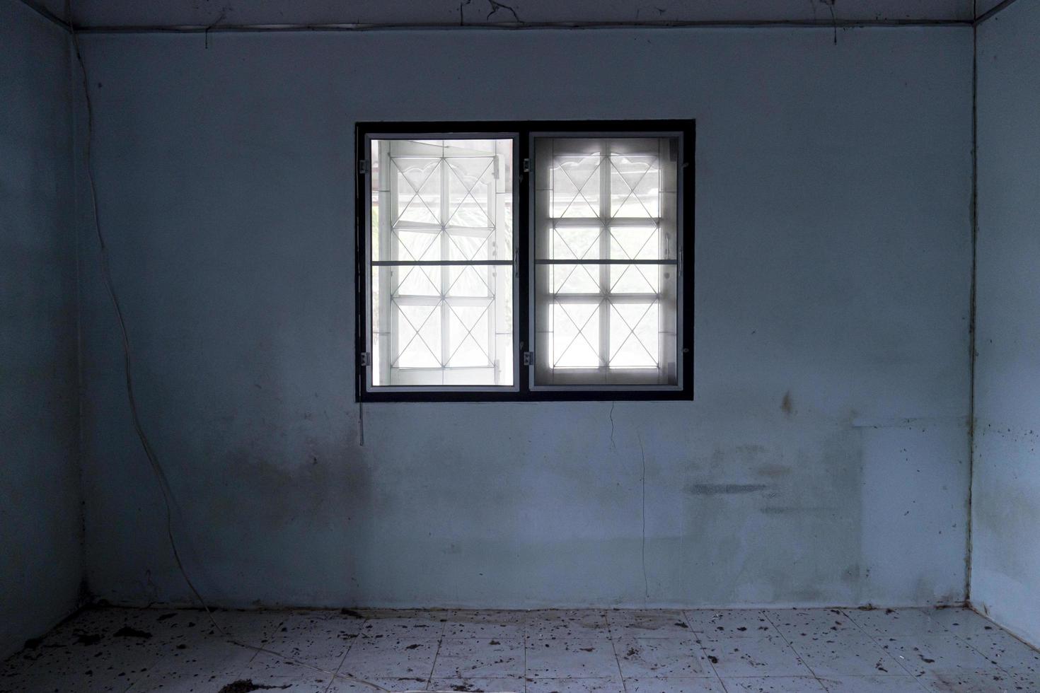finestra all'interno della casa con l'ambiente della casa che è sporco e buio. edifici abbandonati. foto