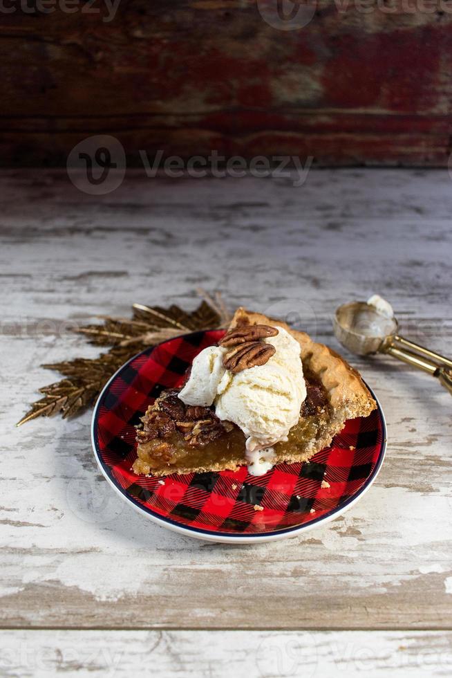 fetta di torta di pecan di natale o festiva con gelato alla vaniglia foto