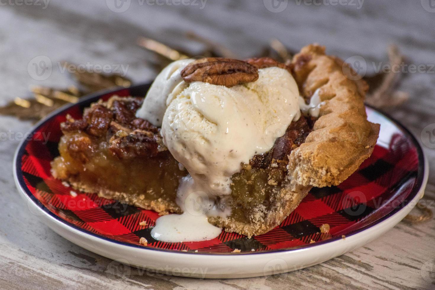 fetta di torta di pecan di natale o festiva con gelato alla vaniglia foto