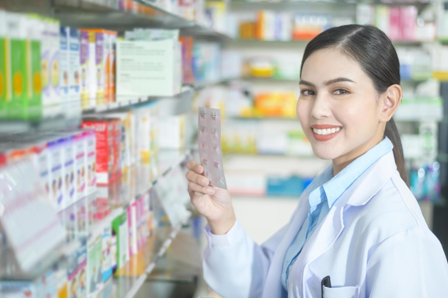 farmacista donna che indossa un camice da laboratorio in una moderna farmacia farmacia., selezionando un medicinale per il cliente. foto