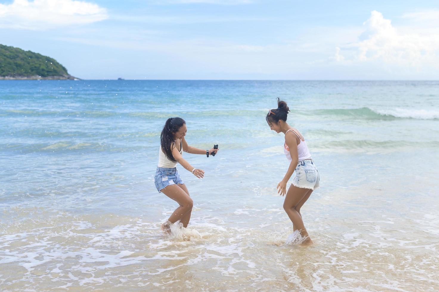 due amiche attraenti che si divertono e si rilassano sulla spiaggia, estate, vacanze, vacanze, concetto di stili di vita. foto