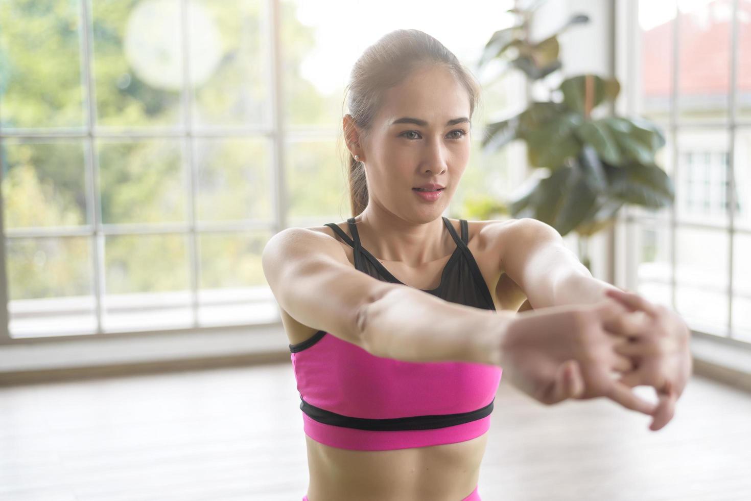 giovane donna in forma che fa yoga e meditazione a casa, sport e concetto di stile di vita sano foto