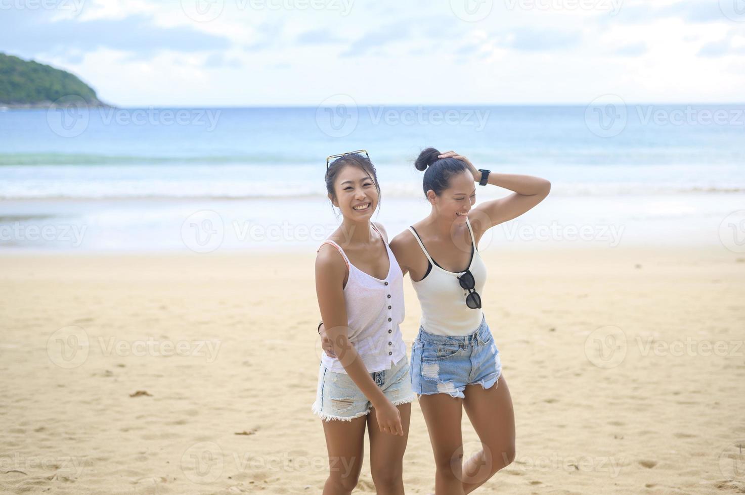 due amiche attraenti che si divertono e si rilassano sulla spiaggia, estate, vacanze, vacanze, concetto di stili di vita. foto