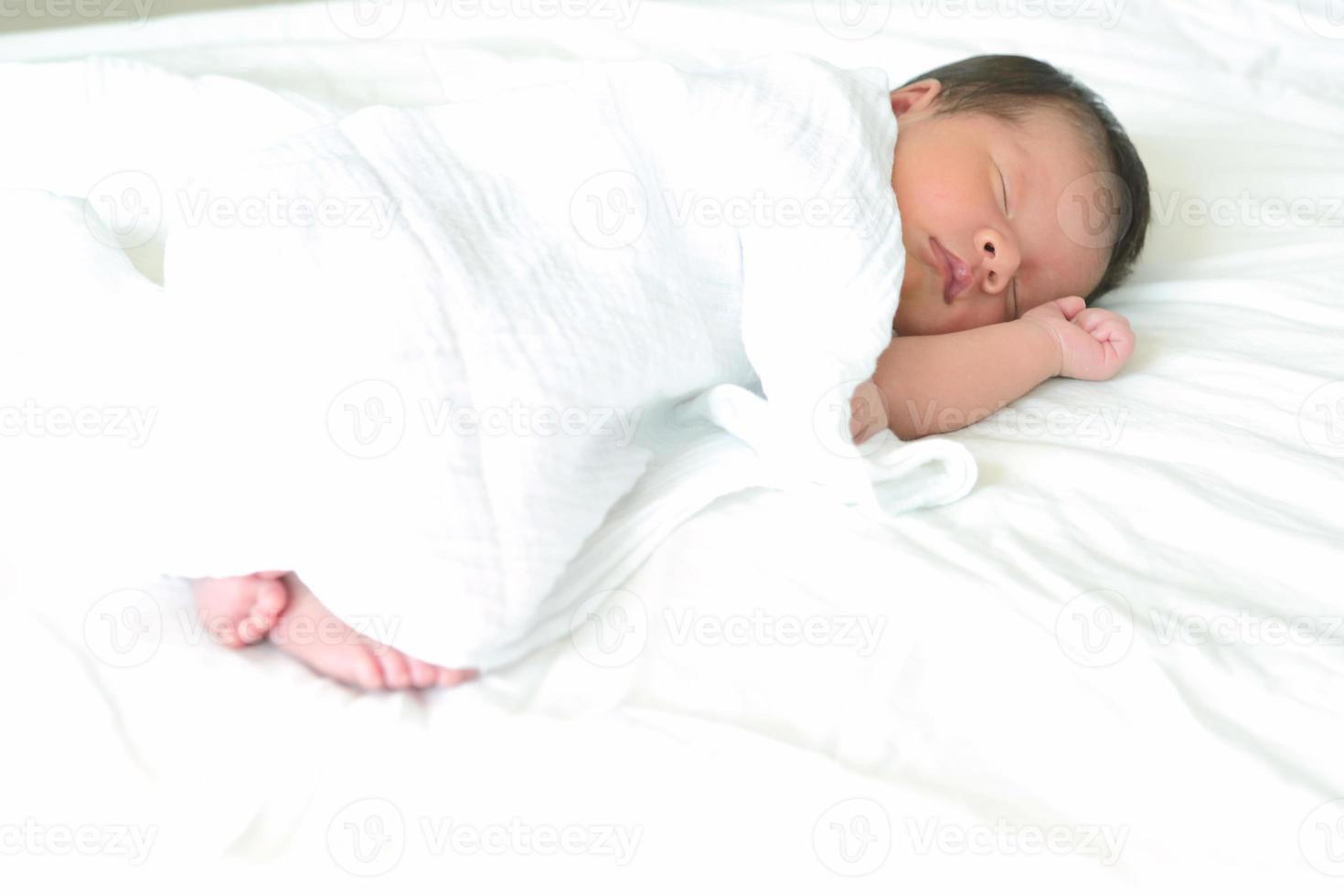 bambino asiatico che dorme sul letto, sano con la madre per il nuovo concetto di famiglia foto