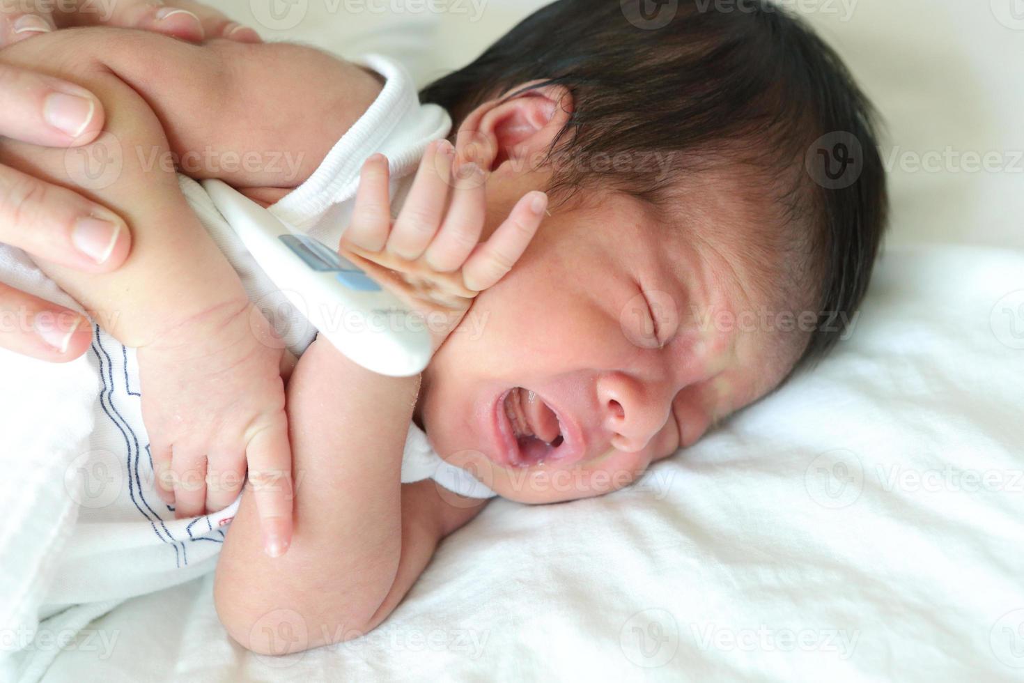 neonato asiatico che dorme sul letto, sano con la madre per il nuovo concetto di famiglia foto