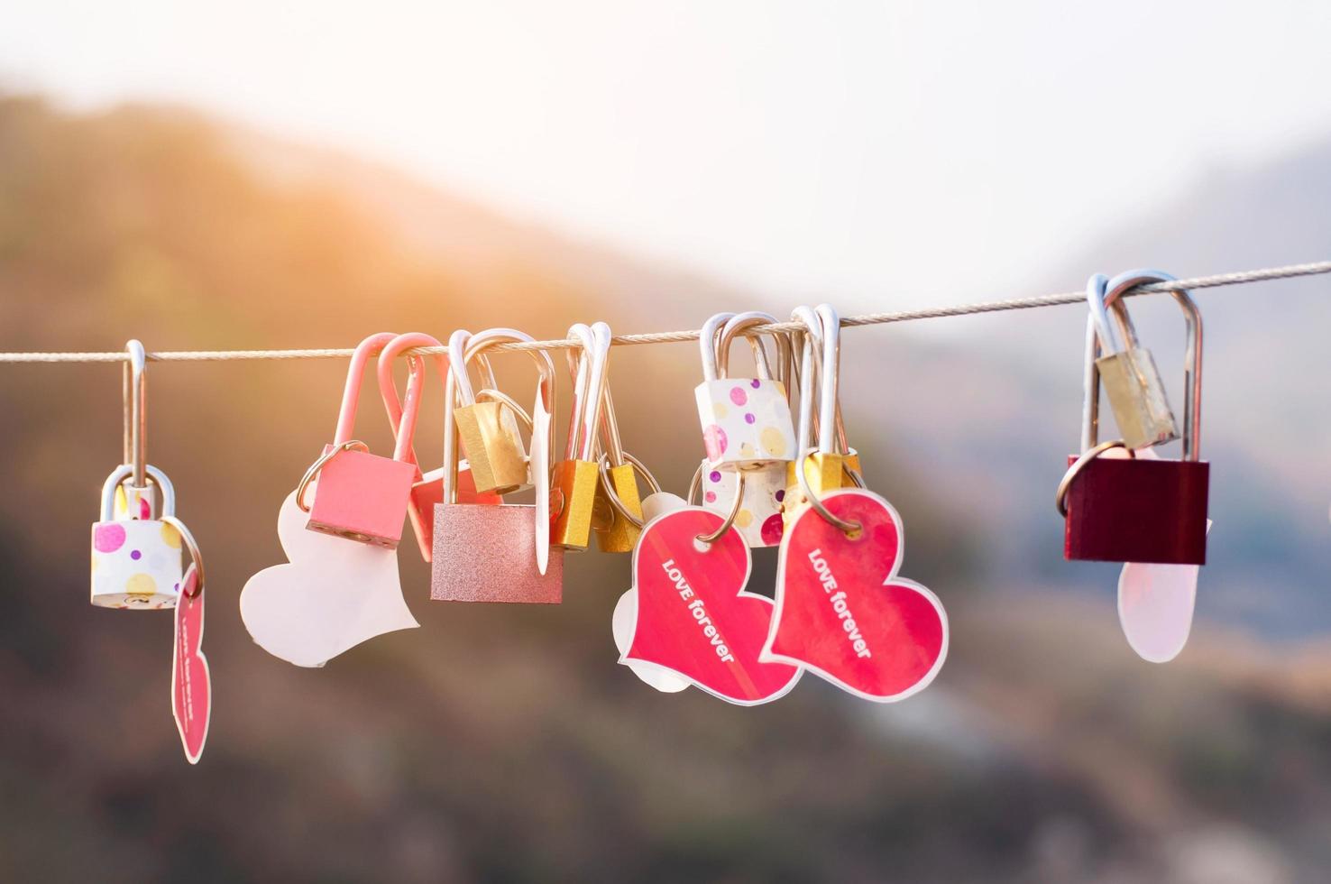 chiave del lucchetto con il simbolo del cuore dell'amore sul ponte - concetto di simbolo della cultura del segno di amore foto