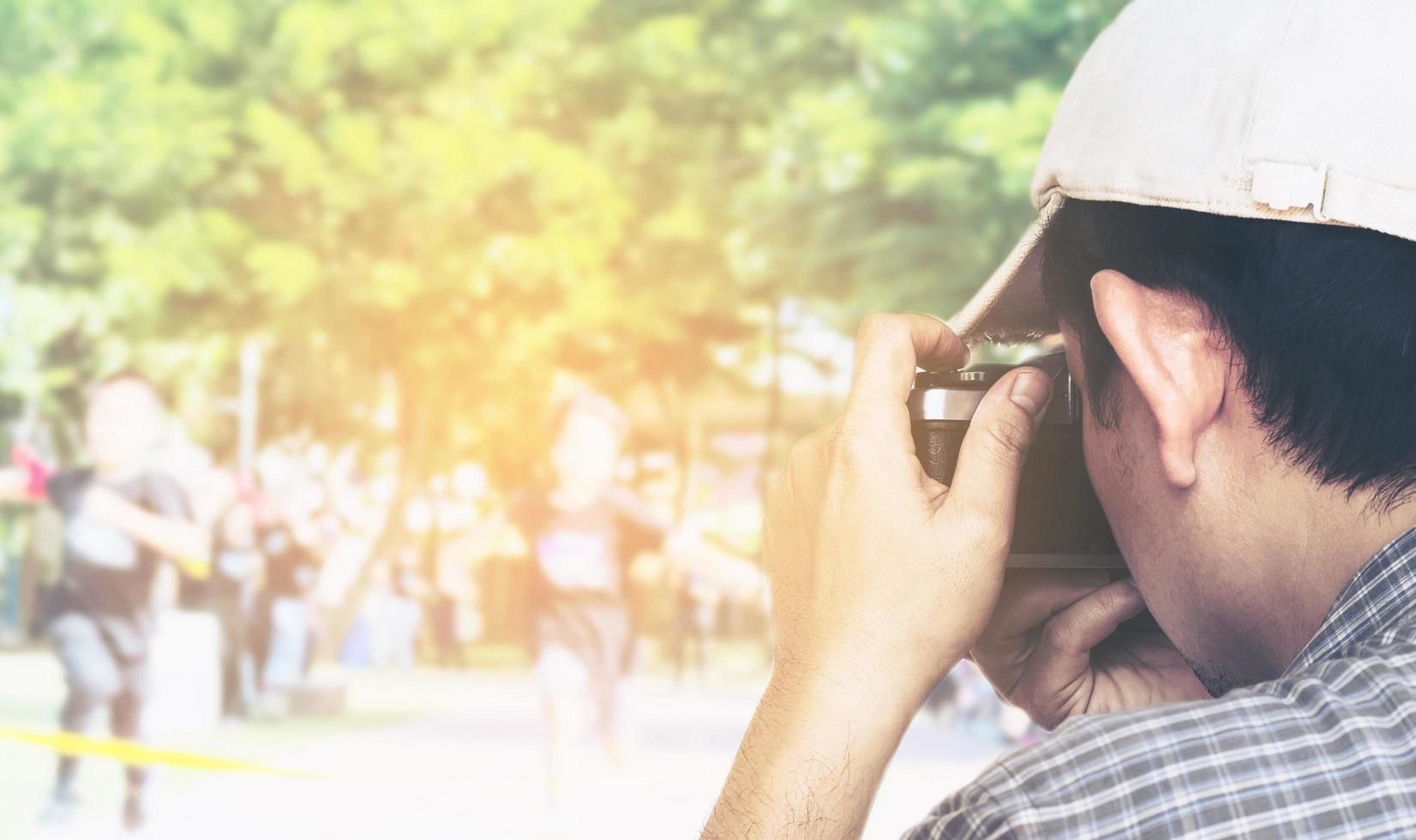 uomo che tiene la fotocamera a pellicola pronta a scattare foto sullo sfondo della competizione sportiva