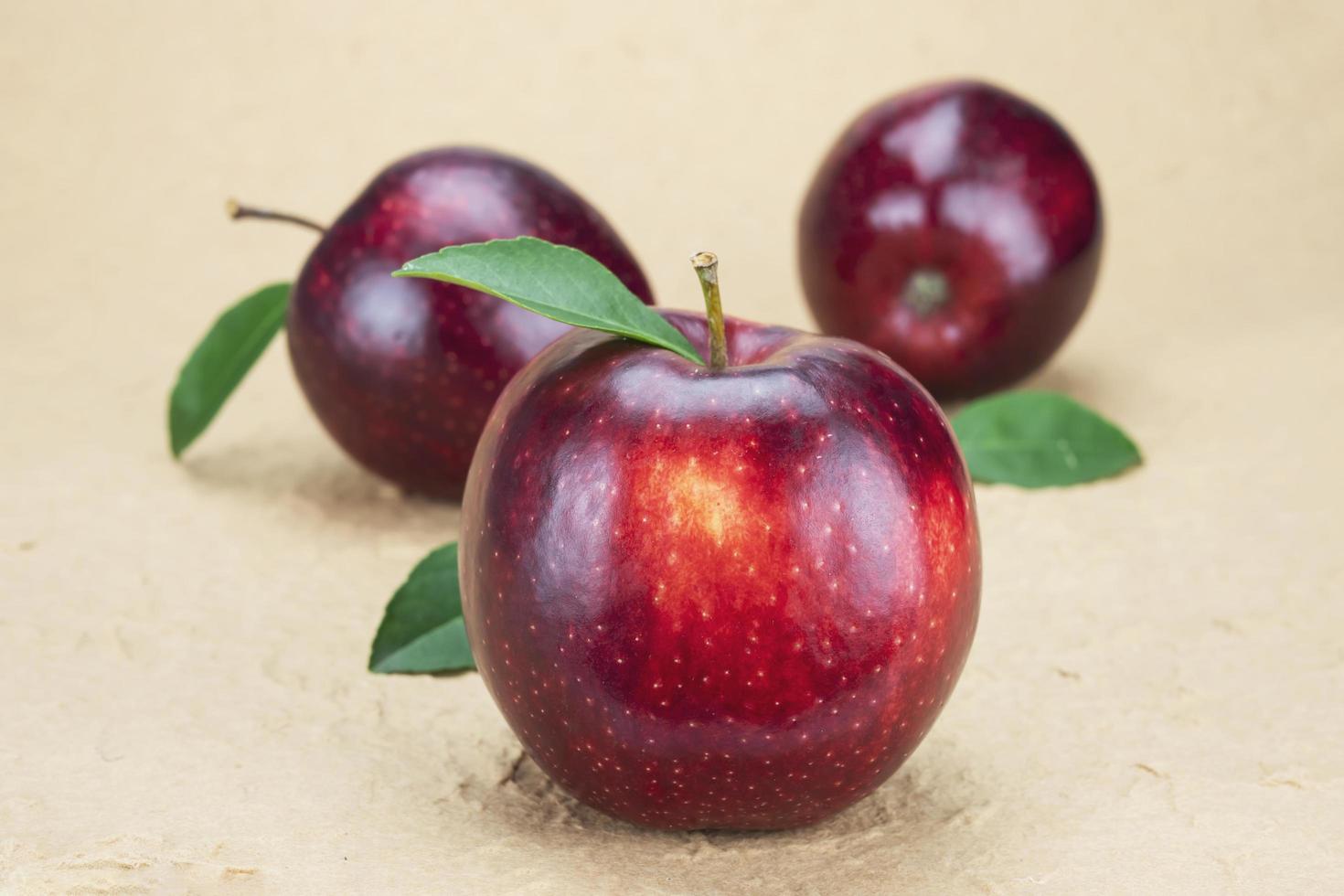 mela rossa fresca su sfondo marrone morbido - concetto di sfondo di frutta fresca foto