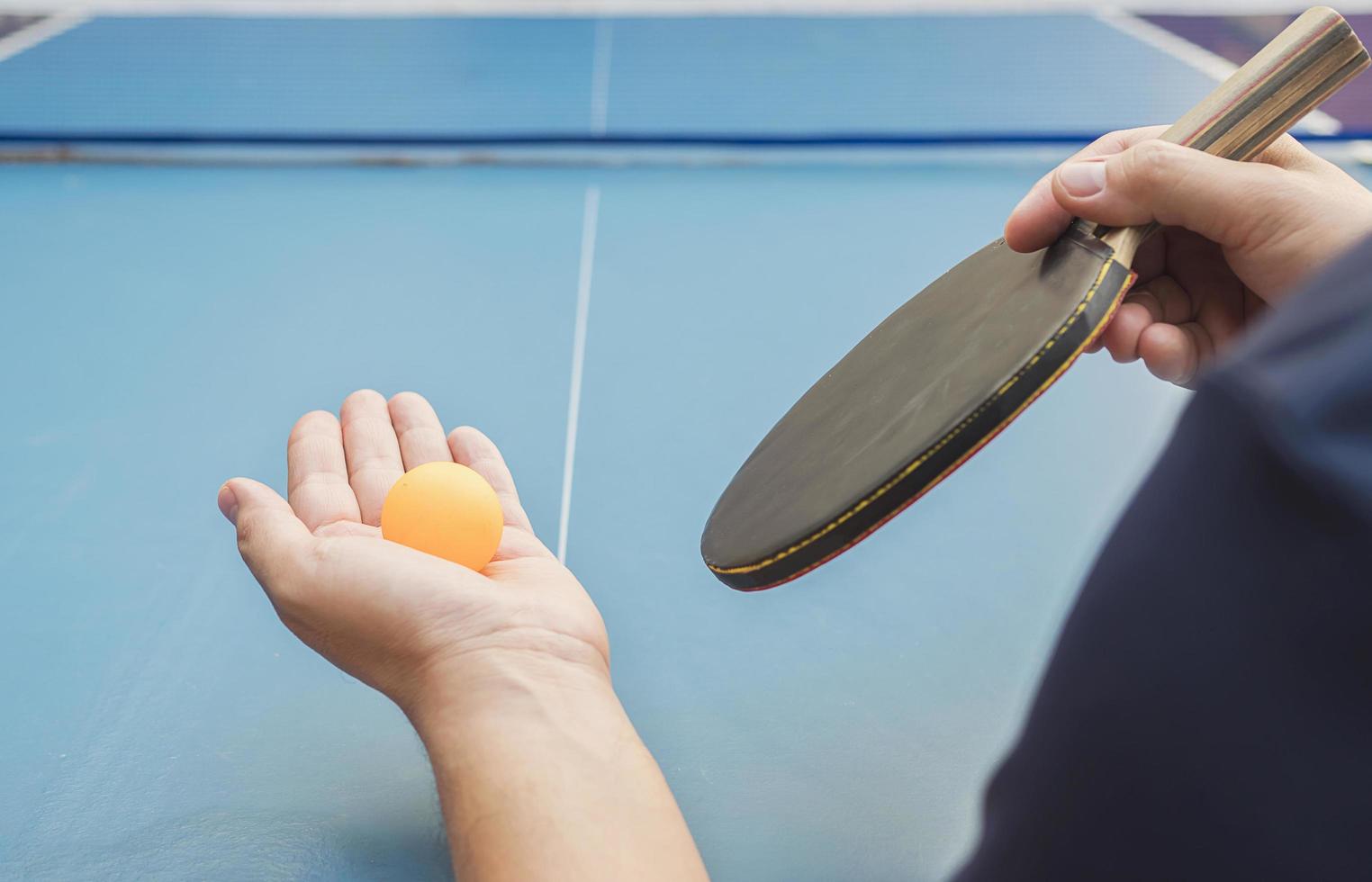 un uomo gioca a ping pong pronto a servire foto