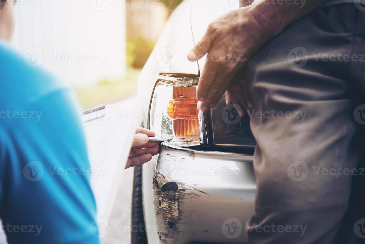 agente assicurativo che lavora durante il processo di richiesta di risarcimento per incidente stradale in loco - concetto di richiesta di risarcimento per le persone e l'assicurazione auto foto