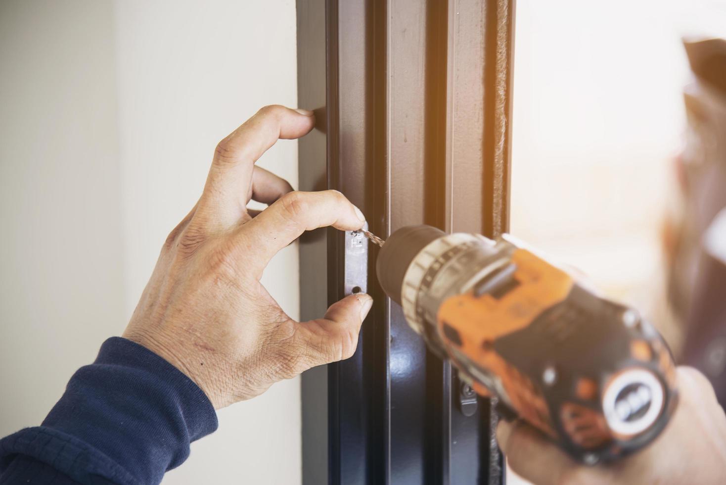 uomo che fa un telaio in alluminio con vetri e filo schermato, porte e finestre, lavori di installazione in cantiere foto