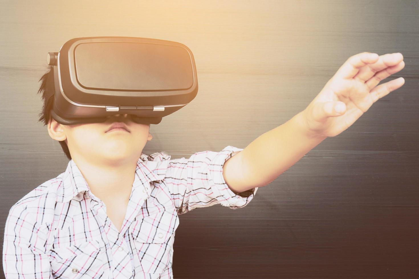 Bambino di 7 anni che gioca a un gioco di realtà virtuale vr foto