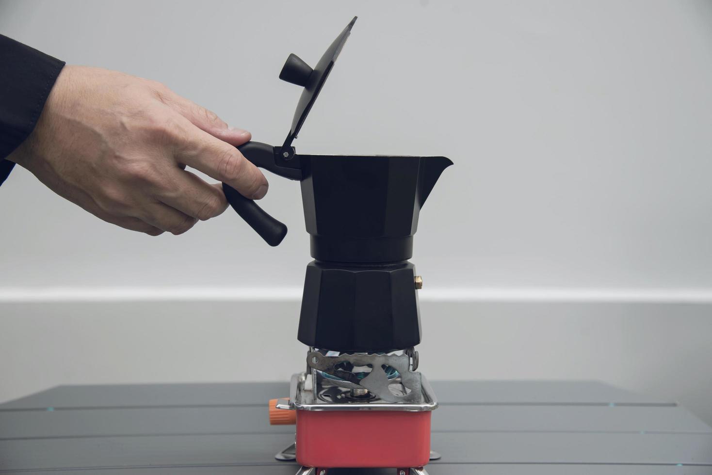 il barista asiatico sta preparando il caffè caldo usando la moka foto