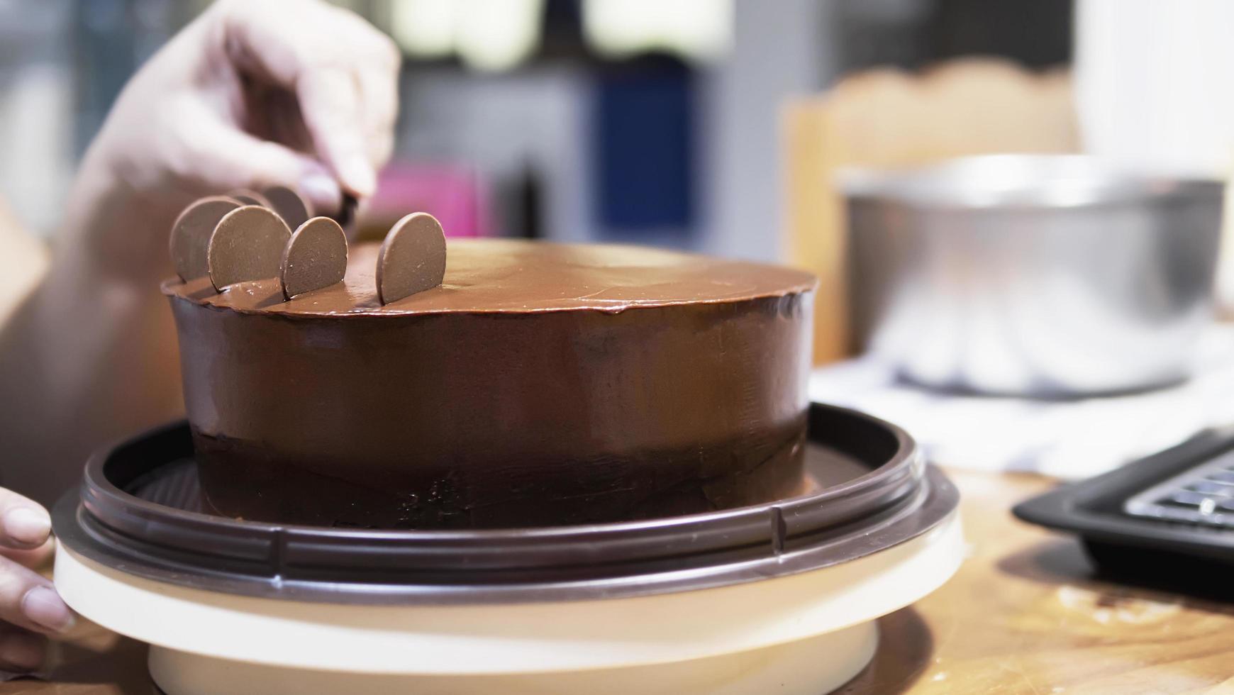 signora che fa la torta al cioccolato - persone con il concetto di panetteria fatta in casa foto