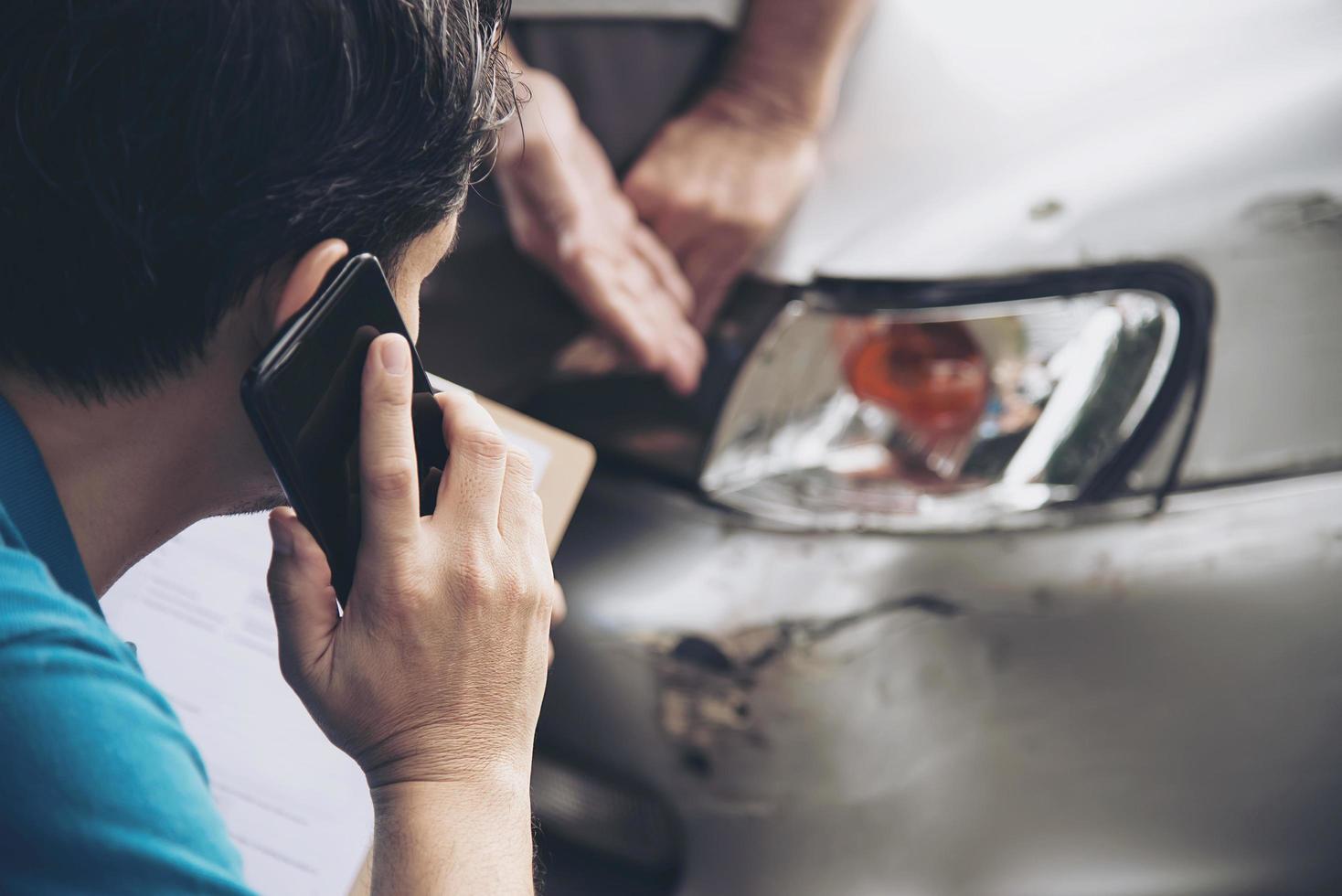 agente assicurativo che lavora durante il processo di richiesta di risarcimento per incidente stradale in loco - concetto di richiesta di risarcimento per le persone e l'assicurazione auto foto