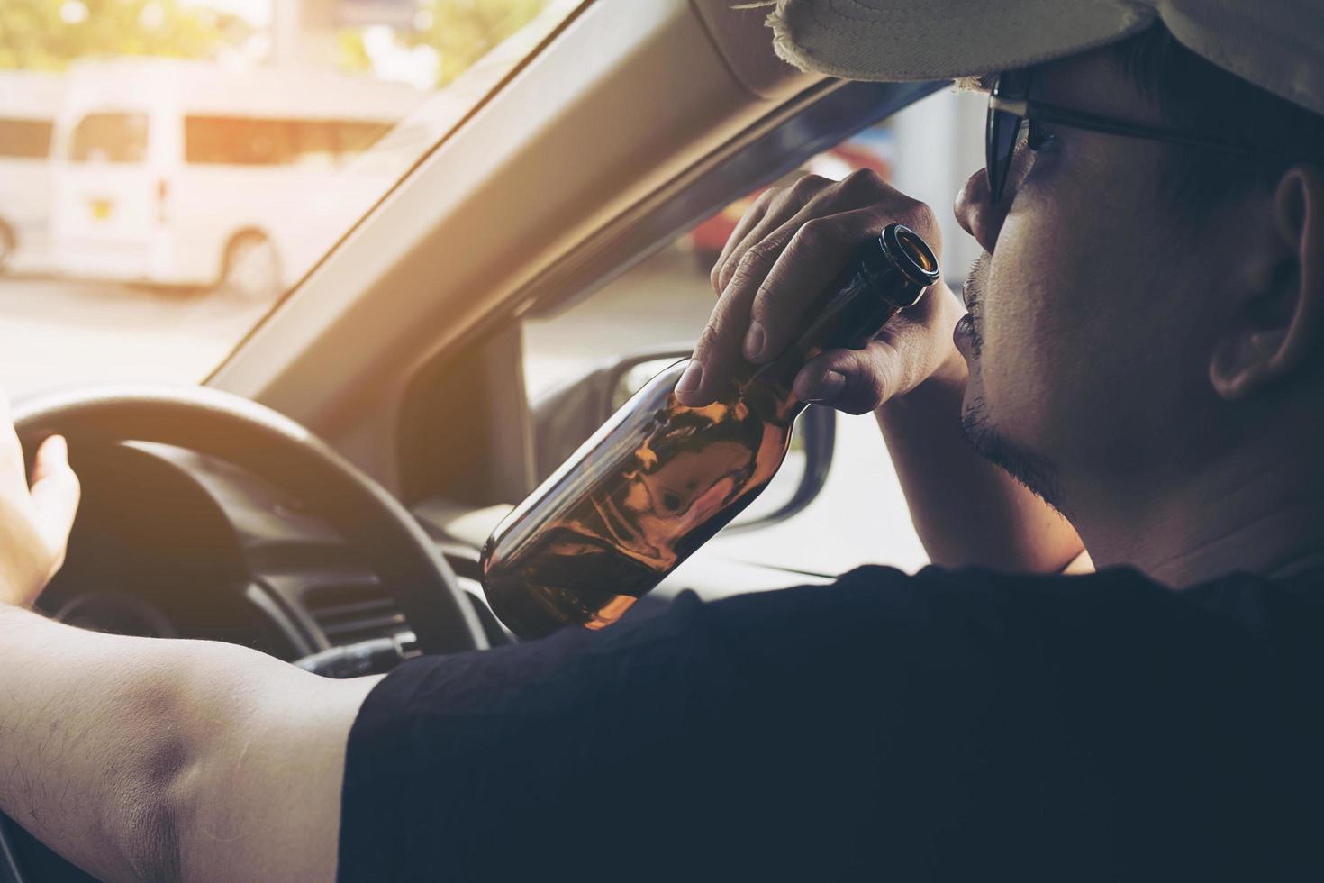 uomo che beve birra mentre guida un'auto foto