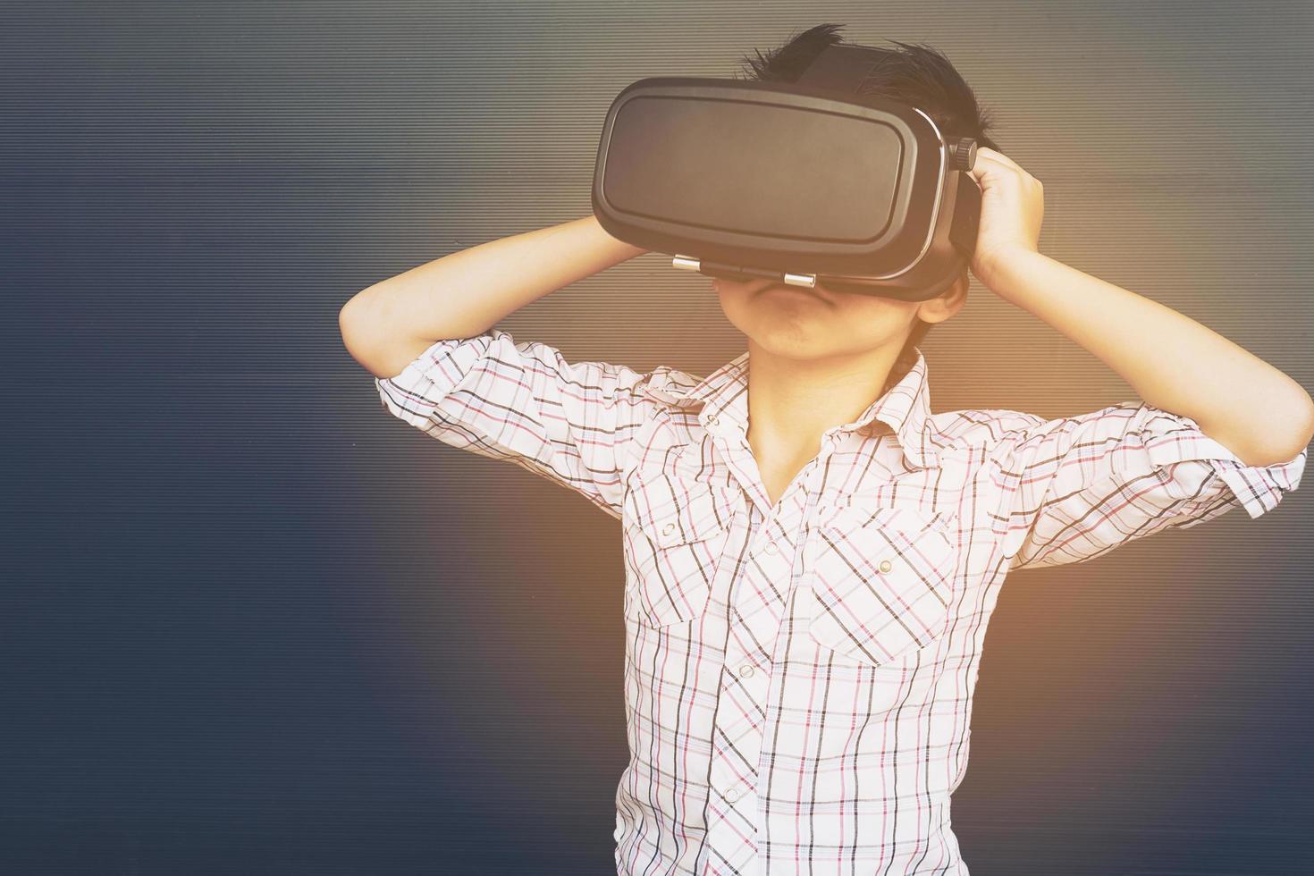 Bambino di 7 anni che gioca a un gioco di realtà virtuale vr foto