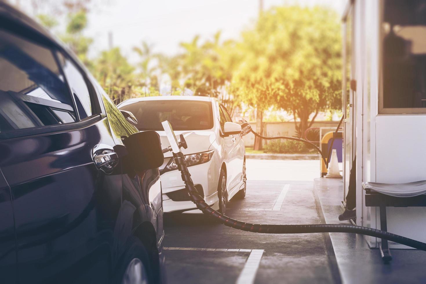 ngv, veicolo a gas naturale, erogatore di testa con un'auto presso la stazione di servizio in thailandia foto