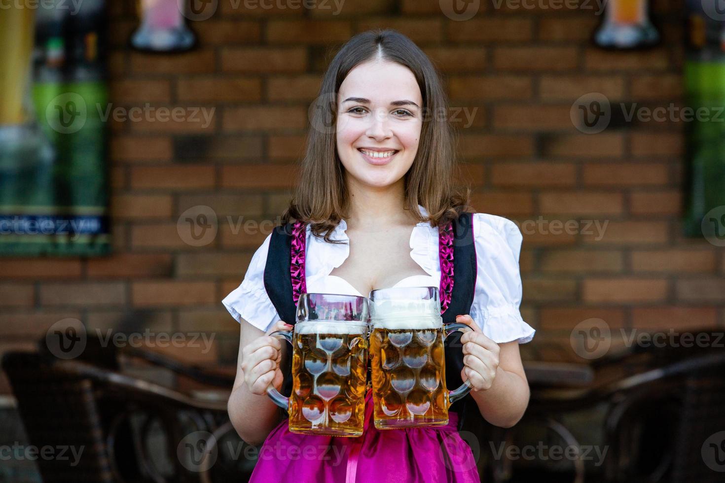 donna russa sexy in vestito bavarese che tiene boccali di birra. foto