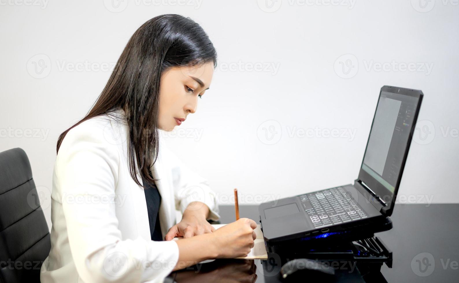 l'asiatico donna d'affari abbigliamento casual utilizzando laptop che lavora in soggiorno a casa. foto