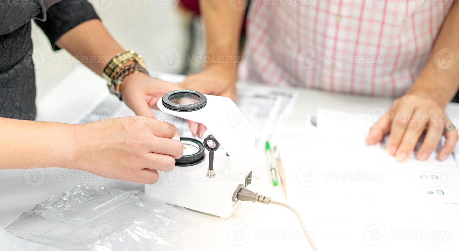 l'esperienza gemmologica nel suo laboratorio fissa il valore della pietra preziosa del polariscopio. foto