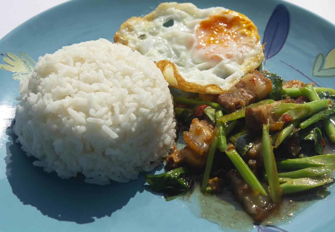 cavolo di maiale croccante - l'uovo fritto è un piatto tailandese piccante e delizioso che è facile da trovare in Thailandia. servito in un piatto azzurro alla calda luce del sole mattutino - è un fast food. foto