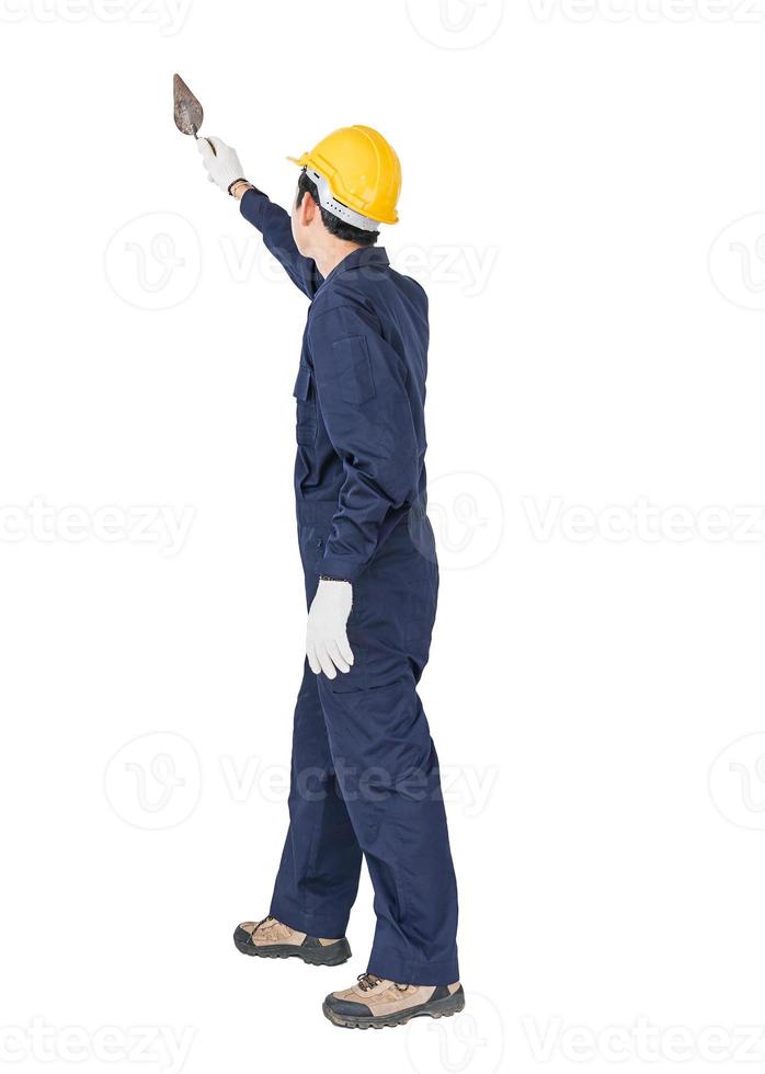 operaio con tute blu ed elmetto protettivo in uniforme che tiene una cazzuola d'acciaio foto