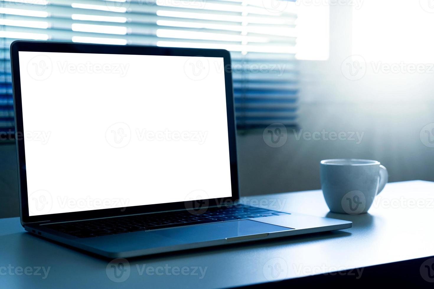 computer portatile con schermo vuoto e una tazza di caffè sul tavolo foto